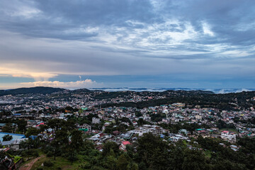downtown city view with dramatic cloudy sky at evening from mountain top