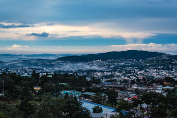 downtown city view with dramatic cloudy sky at evening from mountain top