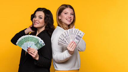 Two Rich Girlfriends Rejoicing Win While Holding Fans of Cash Money Dollars and Euros. Young Women...