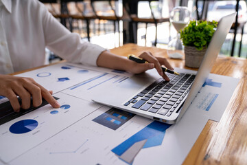 Businesswoman uses a laptop for a marketing project while analyzing company turnover using a laptop computer. An accountant working in an office initiates a planning management collaboration.