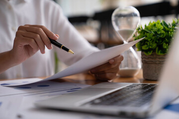 Businesswoman holding graph pen to analyze marketing plan, turnover and profit, calculating taxes...