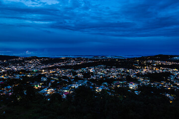 downtown city night view with lighting and dramatic cloudy sky at evening from mountain top