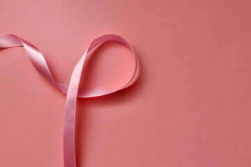 Pink ribbon on a pink background. A symbol of the fight against breast cancer