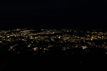downtown city night view with lighting with dark black background from mountain top