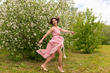 Naklejka na ściany i meble A woman near a blooming spring tree. Romantic happy mood.