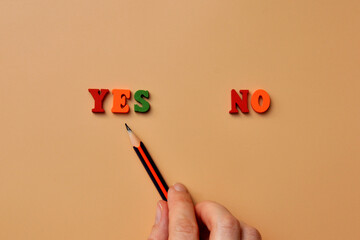 Words: Yes and No made of wooden letters. A choice between Yes and No in life. A choice for or...