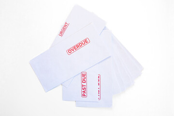 Stack of postal envelopes marked urgent, overdue, past due