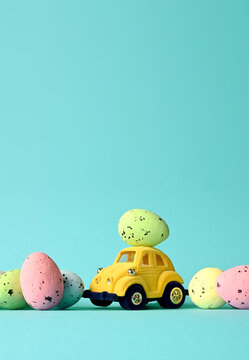 One Easter egg on a small car on a blue background. Copy space.