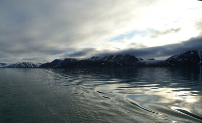 malownicze ośnieżone góry odbijające się w tafli wody w regionie svalbard na arktyce - 489397724
