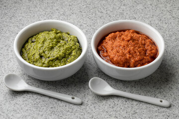 White bowls with red and green Italian pesto close up 