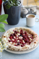 Dessert pizza with raspberries in a plate on the table