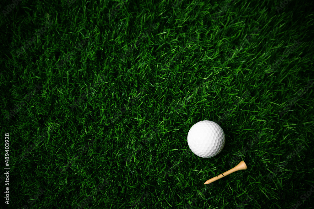 Wall mural golf ball close up on green grass on blurred beautiful landscape of golf background.concept internat