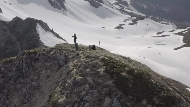 Solitary hiker on top of the mountain in remote snowy area