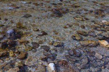 River water surface with stones and pebbles at the river bottom, nature texture background