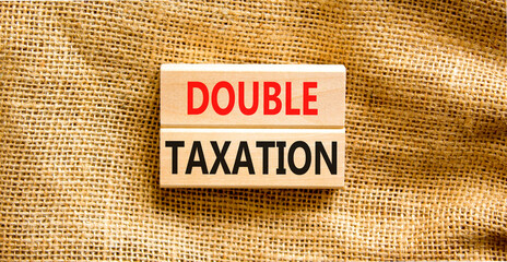 Double taxation symbol. Concept words Double taxation on wooden blocks on a beautiful canvas table canvas background. Business tax and double taxation concept, copy space.