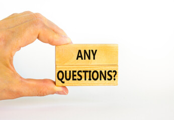 Any questions symbol. Concept words Any questions on wooden blocks on a beautiful white table white background. Businessman hand. Business and Any questions Q and A concept, copy space.