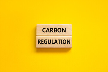 Carbon regulation symbol. Concept words Carbon regulation on wooden blocks on a beautiful yellow table yellow background. Business and carbon regulation concept, copy space.