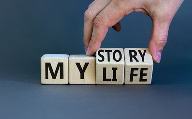Story of my life symbol. Businessman turns wooden cubes and changes concept words My story to My life. Beautiful grey table grey background. Business story of my life concept. Copy space.