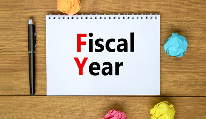 FY Fiscal year symbol. Concept words FY Fiscal year on white note. Metallic pen. Beautiful wooden background. Business and FY fiscal year concept.