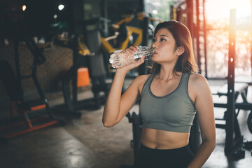 Fototapeta na wymiar happy sport women exercise drink water workout smile training at the gym. athlete girl training strong and good health and strength