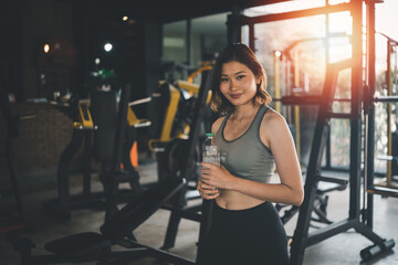 Fototapeta na wymiar happy sport women exercise drink water workout smile training at the gym. athlete girl training strong and good health and strength