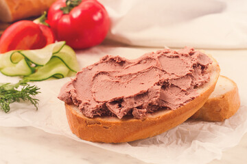 Liver meat pate spread on white bread, on a light background, breakfast, close-up, no people,...