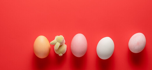 Easter holiday concept. Easter banner picture, multi-colored eggs, spring flowers on a red background. Happy Easter