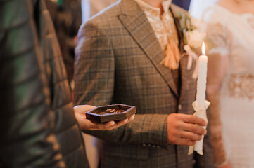 A pair of wedding gold rings in the hands of the groom. Wedding rings on a man's hand