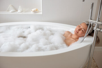 Beautiful adult lady lying in the bathtube