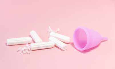 Menstrual cycle. Alternative means of hygiene and protection in critical days for women.Tampons or silicone menstrual cup on  pink background. Сoncept : reuse, eco, safety. Selective focus. Copy space