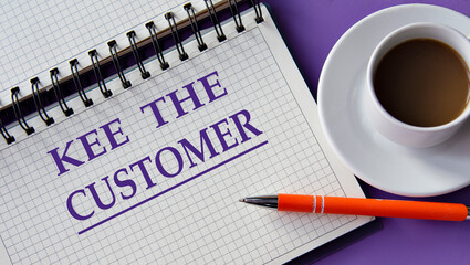 KEE THE CUSTOMER - words in a white notebook on a purple background with a cup of coffee