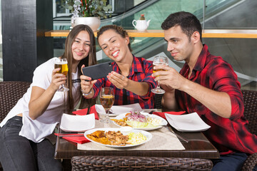 group of friends having lunch in a bar taking a selfie