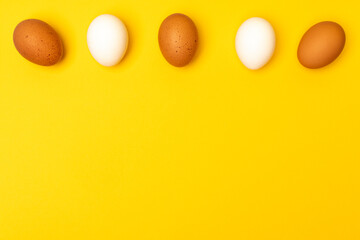 Easter eggs on a yellow background, place for an inscription in the center