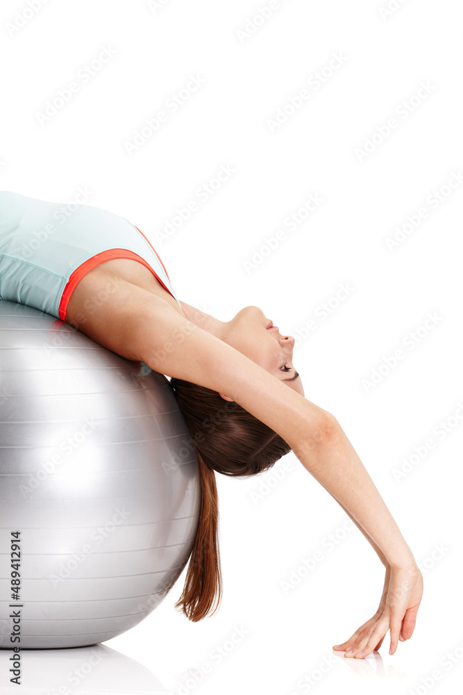 Wall mural Nothing will work unless you do. Shot of a fit young woman exercising with her exercise ball isolated on white.