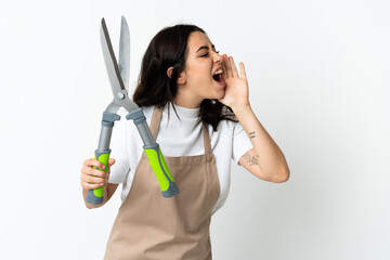 Young caucasian woman holding a plant isolated on white background shouting with mouth wide open to the side