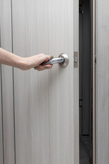 a woman's hand opens an interior door by the handle