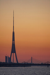 Fototapeta na wymiar Riga TV Tower, bridges and the Daugava River at sunset