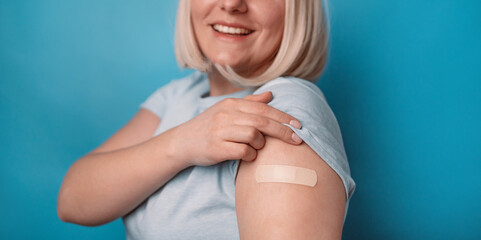 Vaccinated 30s girl getting a vaccine protection the coronavirus. Happy female showing arm with...