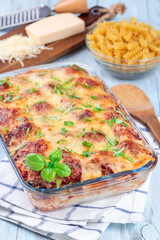 Mac and cheese with meatballs, mozzarella, tomato sauce and basil, in backing dish, vertical