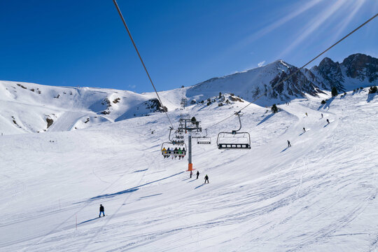 People Riding Ski Lift In Ski Resort