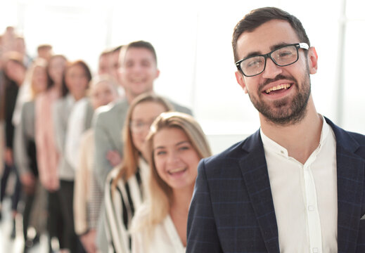 smiling business man standing in front of a group of diverse young people