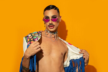 young drag queen in colorful dress on yellow background
