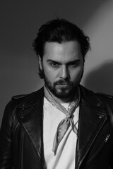 Black and white vertical photo of bearded stylish handsome confident man.