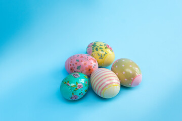 Bright multi-colored eggs in film lie on a blue background. Easter card