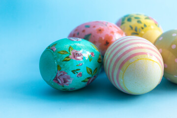 Bright multi-colored eggs in film lie on a blue background. Easter card