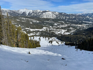 Scenic view of the snow covered slopes and mountains at Big Sky Ski Resort in Montana on a sunny winter day