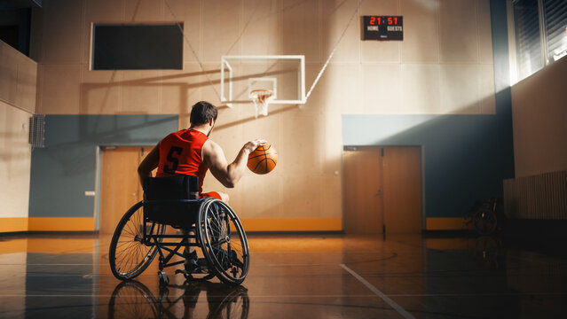 Wheelchair Basketball Player Dribbling Ball Like a Professional, Ready to Shoot and Score Goal. Determination, Motivation of a Person with Disability Excelling at Team Sport. Back View Shot