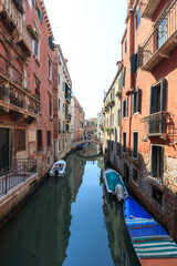 Fototapeta na wymiar Small canal in Venice with boats and bridge, Italy