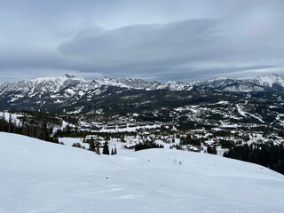 Fototapeta na wymiar Moody view of the mountains and slopes of Big Sky Ski Resort on a cloudy winter day
