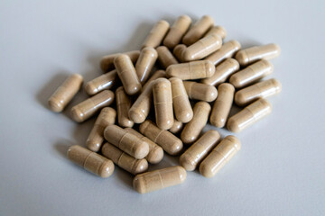 Brown capsules close-up scattered on a light background.